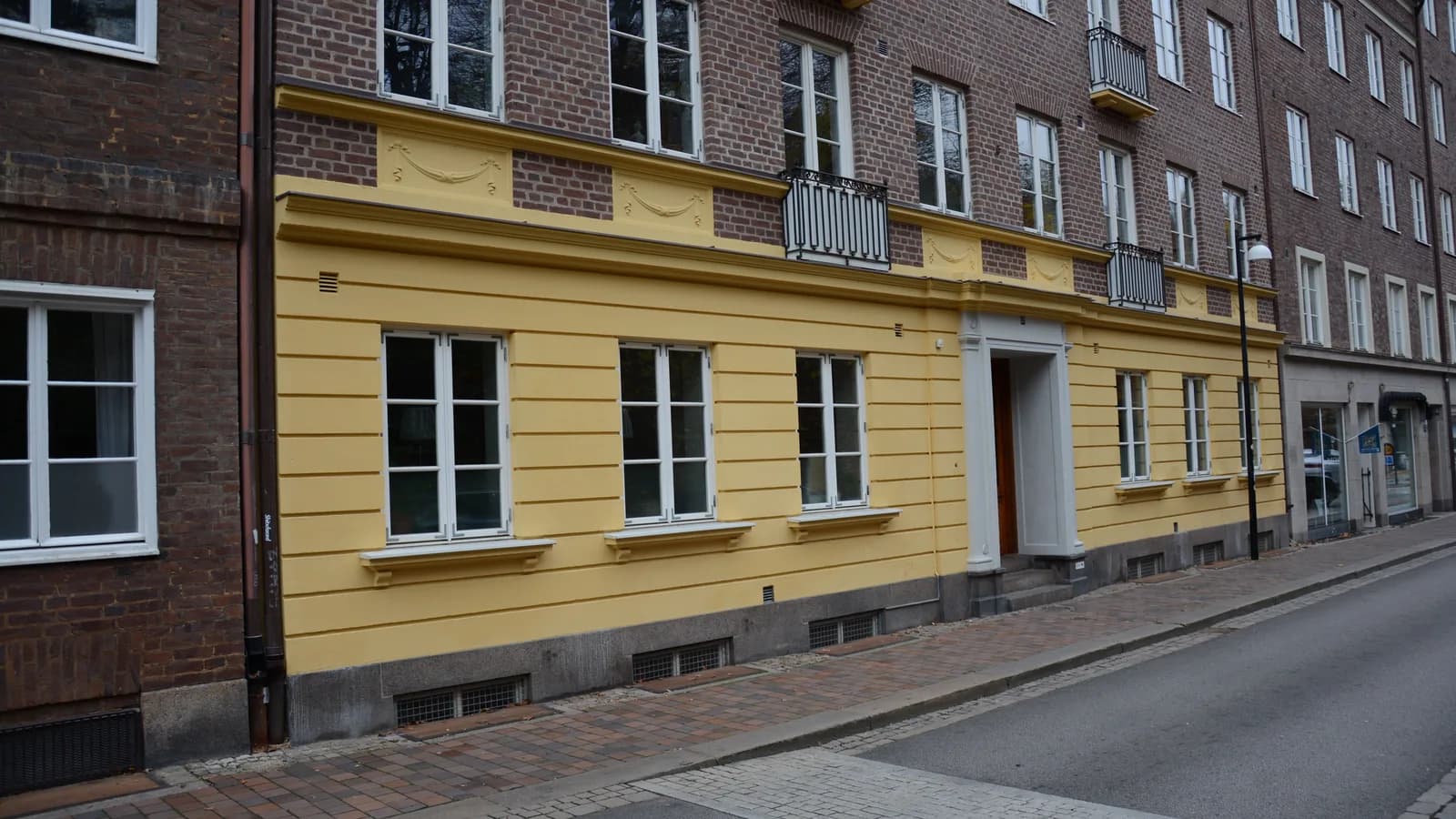 Fassade eines gründerzeitlichen Mehrfamilienhauses mit Stuckgesims und hohen Fenstern