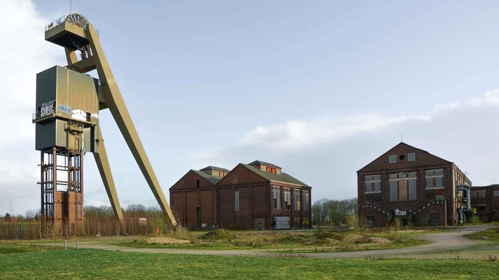 Erhaltenes Zechengebäude aus Backstein vor bewölktem Himmel